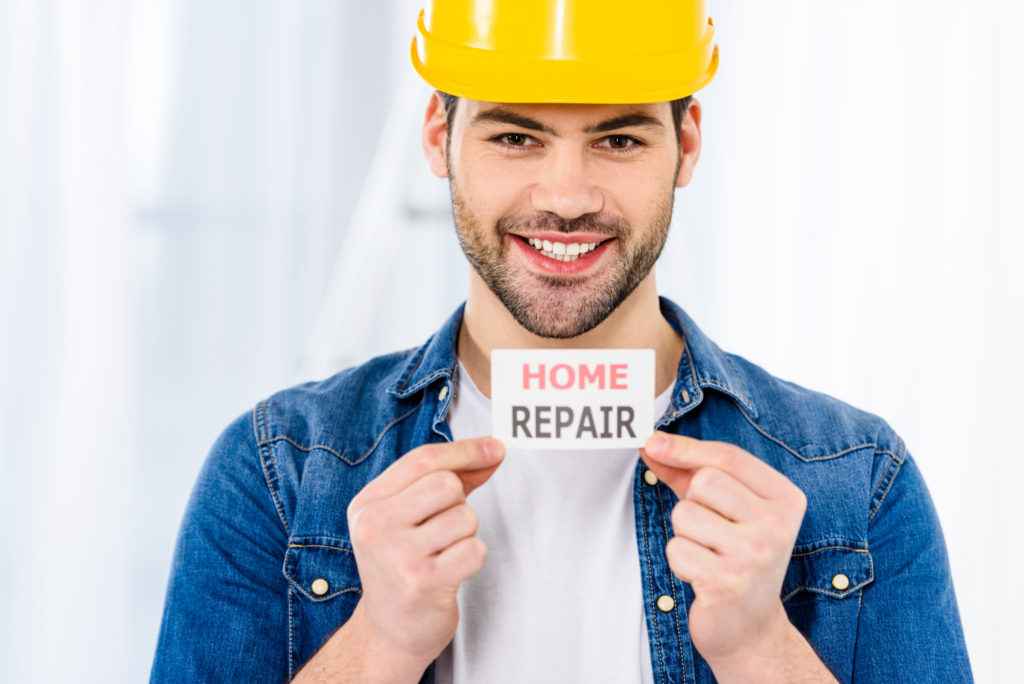 smiling handsome man holding home repair card