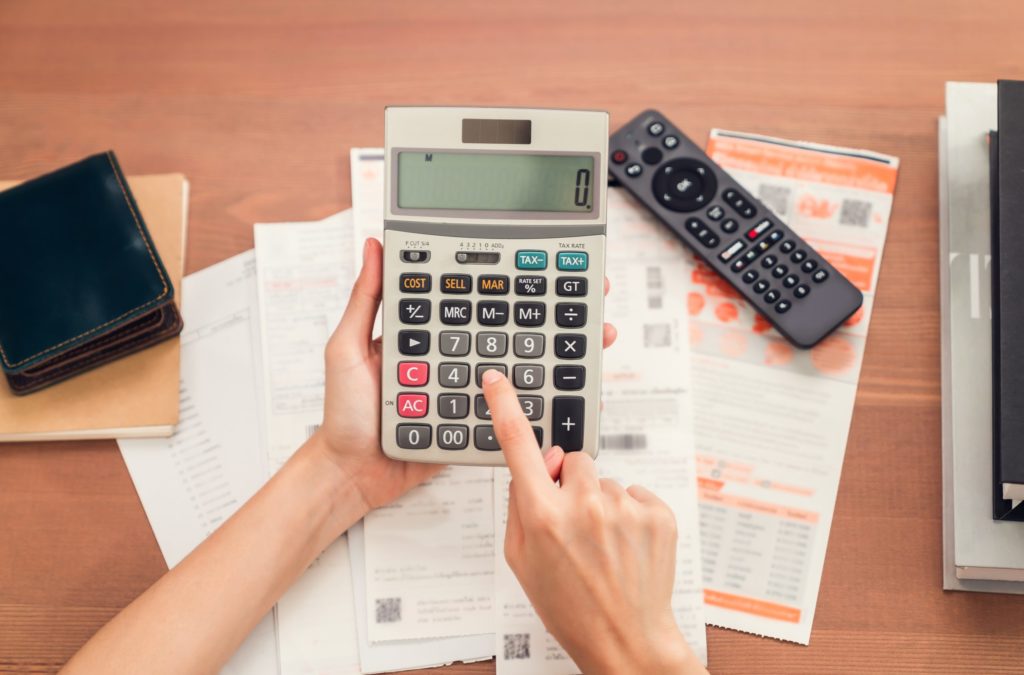 Woman holding and press calculator to calculate income expenses and plans for spending money on home